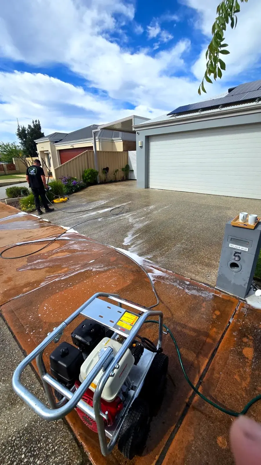 Pressure washing equipment set up for cleaning an exposed aggregate driveway in Perth